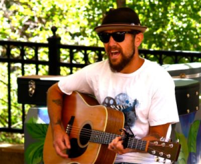 Aaron Reed of The Brothers Reed plays live music at the Lithia Artisans Market of Ashland, Oregon.